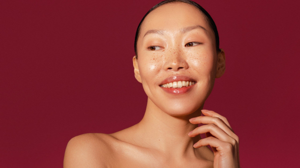 Image contains a model with glass skin on a red background